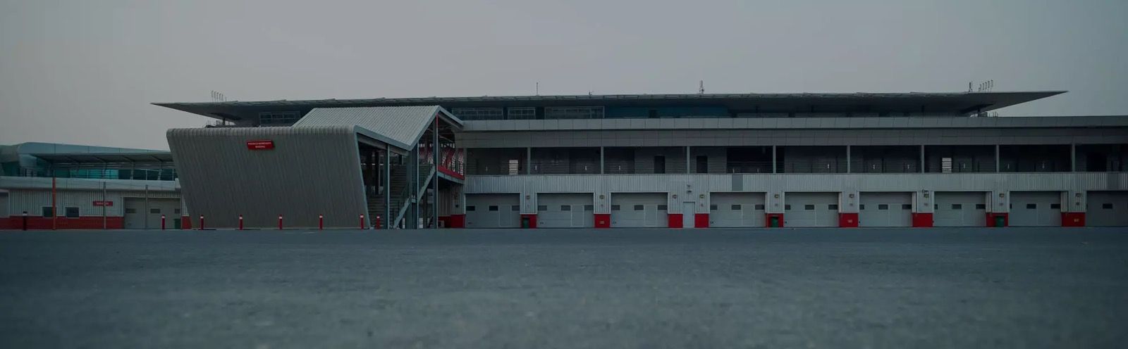 A race car on the Dubai Autodrome circuit at dusk